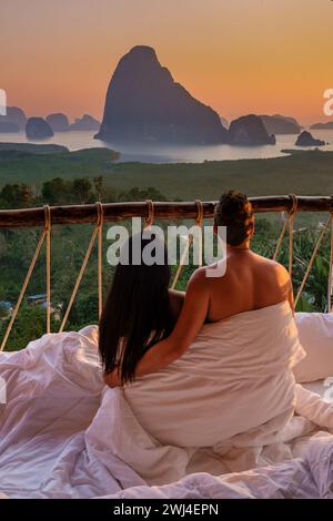 Una coppia in una camera da letto all'aperto al punto panoramico di Sametnangshe sulle montagne nella baia di Phangnga in Thailandia Foto Stock