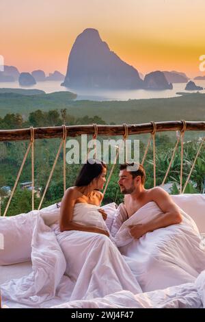 Una coppia in una camera da letto all'aperto al punto panoramico di Sametnangshe sulle montagne nella baia di Phangnga in Thailandia Foto Stock