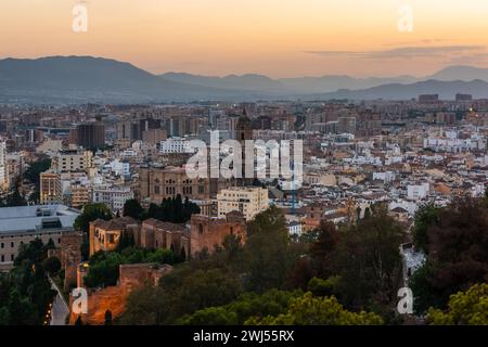 Malaga, il paesaggio urbano della Spagna con la cattedrale, il municipio e la cittadella dell'Alcazaba di Malaga al crepuscolo Foto Stock