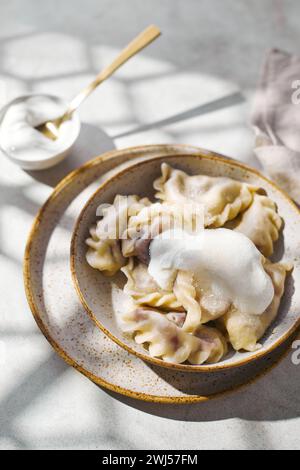 Gnocchi con ciliegie con panna acida e zucchero. Piatto tradizionale di cucina russa, Ucraina e bielorussa conosciuto come Vareniki Foto Stock