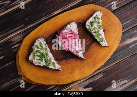 Pezzi di pane con delizioso strutto con cipolle rosse e verdi Foto Stock