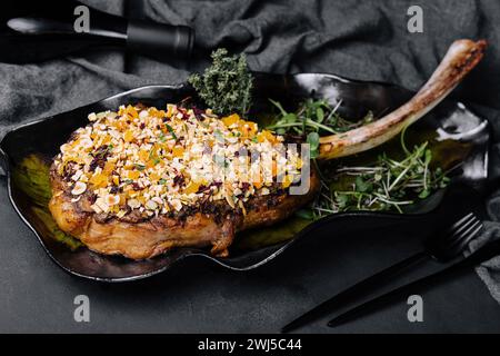 Bistecca di tomahawk al barbecue su piatto nero Foto Stock