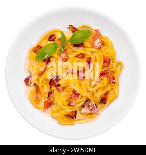 Pasta con pancetta e basilico su piatto bianco Foto Stock