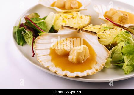 Conchiglia di capesante scottata con burro sul piatto Foto Stock