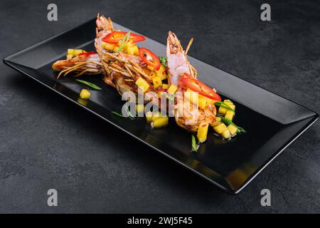 Spiedini barbecue di gamberi grigliati su piatto nero Foto Stock