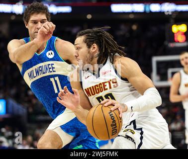 Milwaukee, Stati Uniti. 12 febbraio 2024. L'attaccante dei Denver Nuggets Aaron Gordon (R) guida il centro dei Milwaukee Bucks Brook Lopez durante la partita di stagione regolare 2023-2024 tra Denver Nuggets e i Milwaukee Bucks al Fiserv Forum di Milwaukee, negli Stati Uniti, il 12 febbraio 2024. Crediti: Joel Lerner/Xinhua/Alamy Live News Foto Stock