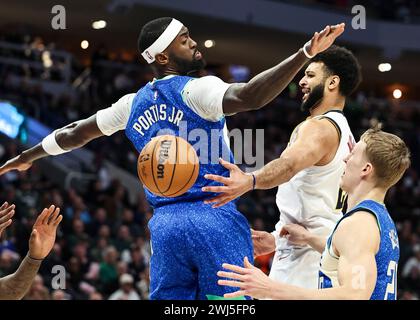 Milwaukee, Stati Uniti. 12 febbraio 2024. La guardia dei Denver Nuggets Jamal Murray (C) passa la palla davanti all'attaccante dei Milwaukee Bucks Bobby Portis (L) durante la partita di stagione regolare 2023-2024 tra Denver Nuggets e i Milwaukee Bucks al Fiserv Forum di Milwaukee, negli Stati Uniti, il 12 febbraio 2024. Crediti: Joel Lerner/Xinhua/Alamy Live News Foto Stock