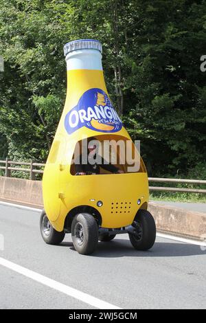 Belleville en Beaujolais, Francia - 13 luglio 2023: Veicolo in bottiglia Orangina durante il passaggio della carovana pubblicitaria durante le Tour de France Foto Stock