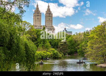 Barche a remi nel lago di Central Park con l'edificio Eldorado in lontananza, Manhattan, New York, Stati Uniti Foto Stock