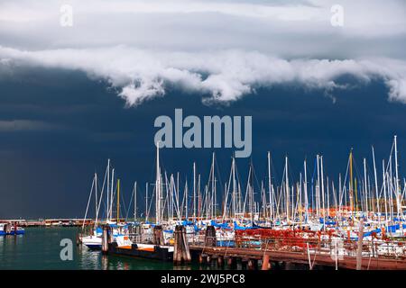 Nuvole d'tempesta che incombono sugli opulenti yacht del porto. Yacht e barche nel porticciolo in una giornata tempestosa Foto Stock