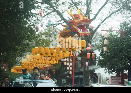 Hangzhou, Cina. 13 febbraio 2024. Il 13 febbraio 2024 i turisti stanno osservando una lanterna drago lunga 300 metri presso la palude di Xixi nel distretto del Lago Ovest di Hangzhou, la capitale della provincia dello Zhejiang della Cina orientale. (Foto di Costfoto/NurPhoto) credito: NurPhoto SRL/Alamy Live News Foto Stock