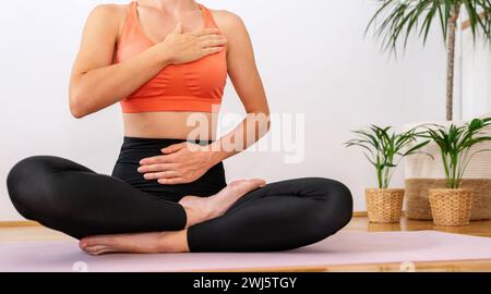 Esercizio respiratorio. Esercizio di meditazione yoga. Donna in posizione loto yoga sul tappetino per esercizi. Foto Stock