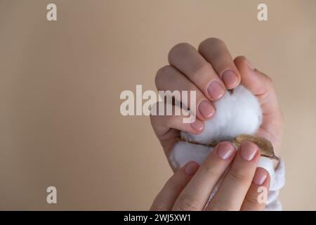 Unghie pastello morbide e curate su sfondo beige neutro. Donna che mostra la sua nuova manicure nei colori della tavolozza pastello. Decorazioni semplici, fresche vibrazioni primaverili dai colori naturali Foto Stock