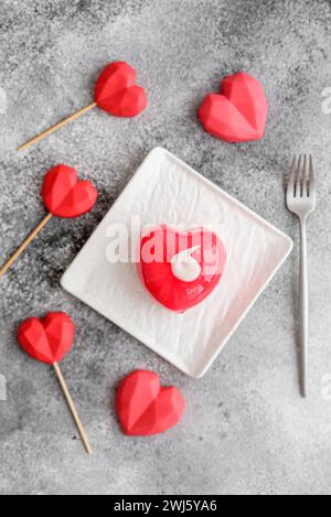 Bella torta di colore rosso cheesecake a forma di cuore Foto Stock