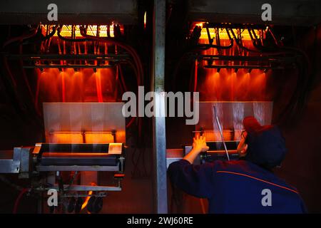 CHONGQING, CINA - 11 FEBBRAIO 2024 - Un lavoratore esegue un'operazione di trafilatura presso l'officina di produzione di un'azienda di fibra di vetro a Chongqing, CH Foto Stock