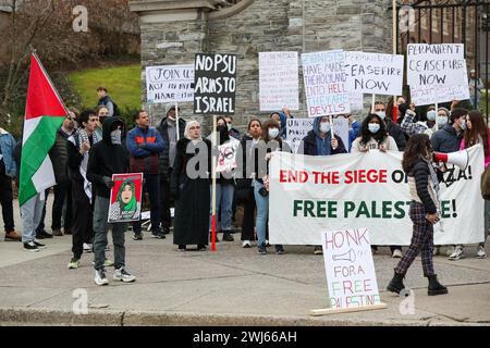 State College, Stati Uniti. 12 febbraio 2024. I manifestanti pro-palestinesi tengono dei cartelli presso i cancelli di Allen Street della Penn State durante la dimostrazione. Credito: SOPA Images Limited/Alamy Live News Foto Stock