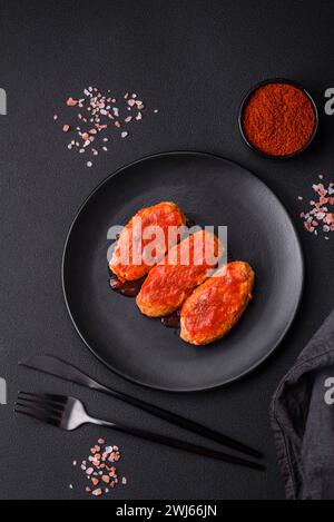 Cotoletta di carne o polpette in salsa di pomodoro con aglio, sale, spezie ed erbe aromatiche Foto Stock