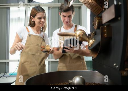Sia della torrefazione che della macchina per torrefazione, controlla la qualità della torrefazione nell'impianto di torrefazione del caffè. Foto Stock