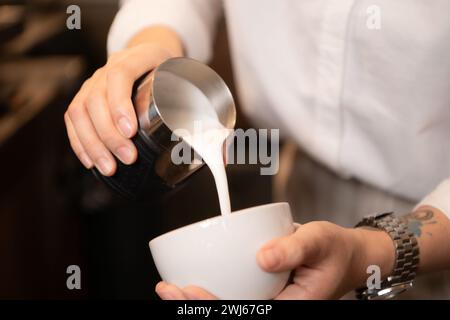 Barista che versa il caffè in una tazza al bar, primo piano Foto Stock