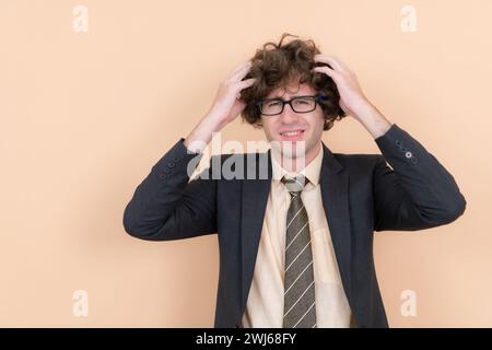 Ritratto di un bel giovane con capelli ricci su sfondo beige Foto Stock