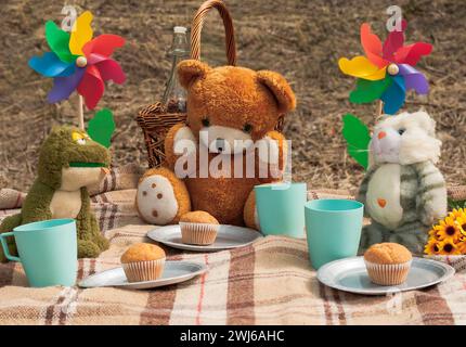 Un assortimento di giocattoli morbidi che si godono un picnic nel bosco Foto Stock