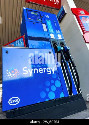 Una pompa di gas esso Synergy blu si trova accanto a una stazione di servizio, pronta a fornire carburante ai veicoli. Foto Stock