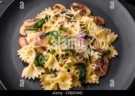 Deliziose farfalle con funghi, formaggio e spinaci con spezie Foto Stock