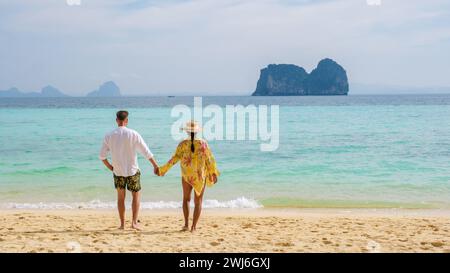 Felice giovane coppia donna asiatica e uomini europei sulla spiaggia dell'isola di Koh Ngai in Thailandia Foto Stock