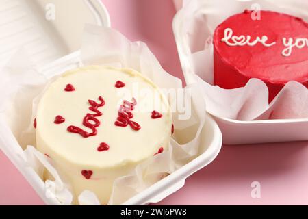 Torte di Bento in scatole da asporto sul tavolo rosa. St La sorpresa di San Valentino Foto Stock