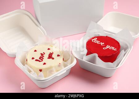 Gustose torte bento in confezioni da asporto sul tavolo rosa Foto Stock