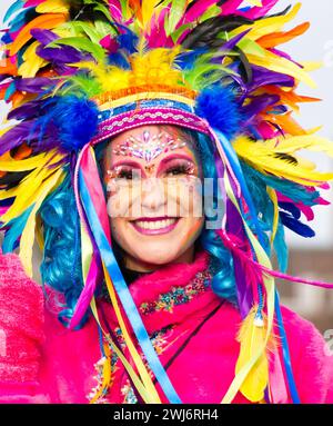 Maastricht, Paesi Bassi. 11 febbraio 2024. Una donna con un colorato volto e un costume impressionante che partecipa alla sfilata di Maastricht la domenica di Carnevale. Anna Carpendale/Alamy Live News Foto Stock