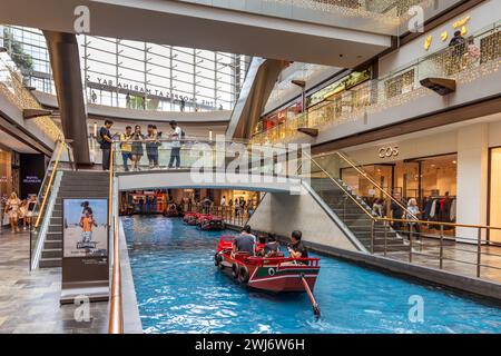 I visitatori che si godono le escursioni IN SAMPAN cavalcano lungo il Canal at the Shoppes at Marina Bay Sands. Foto Stock