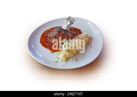 Piatto bianco con agnello e patate schiacciate isolate su bianco Foto Stock