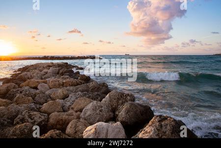 Tramonto sul mare. vista sul mare. Salve vacanze, vacanze, viaggi. Bella combinazione di onde, sole, pietre, nuvole Foto Stock