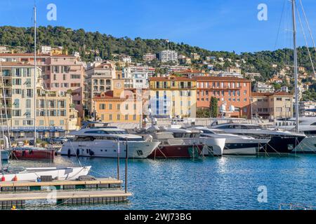 Pittoresca Port Lympia a Nizza. Con yacht di lusso e barche a remi colorate chiamate "pointus". Usate come barche da pesca e ora utilizzate anche dalle famiglie. Foto Stock