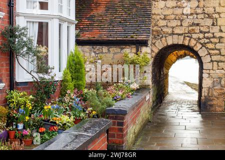 Il Newport Arch e la strada che porta a Bailgate, l'area superiore di Lincoln. Newport Arch è una porta romana del III secolo nella città di Lincoln, nel Lincolnshire. Si tratta di un monumento e di un edificio classificato di grado i ed è considerato l'arco più antico del Regno Unito ancora utilizzato dal traffico. Foto Stock