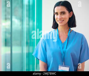 Ritratto di donna matura sorridente Dottore che indossa scrub in ospedale Foto Stock