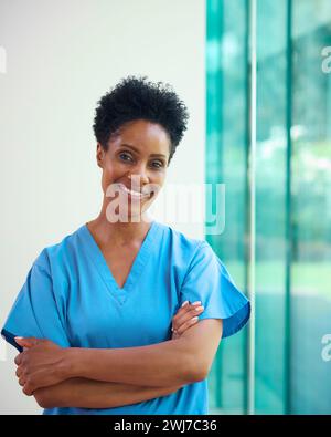 Ritratto di donna matura sorridente Dottore che indossa scrub in ospedale Foto Stock