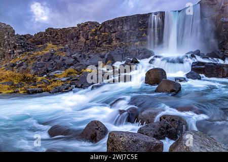 Oxarafoss, o la cascata nel fiume Ax, nel parco nazionale di Thingvellir, Islanda. Lunga esposizione dell'acqua fluente veloce in autunno. Foto Stock