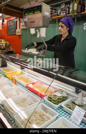 Donna che vende pasta nella sua stalla del vecchio mercato centrale dell'Abaceria di Barcellona Foto Stock