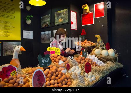 Stalla per uova con il suo proprietario che ne mette alcuni in una scatola di uova nel vecchio mercato centrale dell'Abaceria di Barcellona Foto Stock