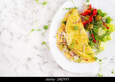 Colazione salutare. Quesadilla con omelette, filetto di pollo, mais e insalata fresca. Keto, pranzo chetogeno. Vista dall'alto Foto Stock
