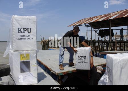 Langkat, Indonesia. 13 febbraio 2024. Gli agenti del KPU spostano le urne da una barca nel villaggio di Jaring Halus. Distribuzione delle urne elettorali in Indonesia. Credito: SOPA Images Limited/Alamy Live News Foto Stock