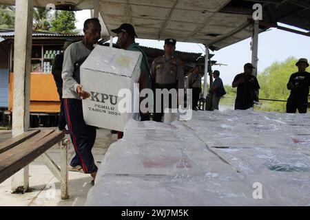 Langkat, Indonesia. 13 febbraio 2024. I membri delle elezioni organizzano le urne accompagnate da agenti di sicurezza della polizia nel villaggio di Tanjung Ibul, sottodistretto di Langkat. Distribuzione delle urne elettorali in Indonesia. (Foto di Kartik Byma/SOPA Images/Sipa USA) credito: SIPA USA/Alamy Live News Foto Stock