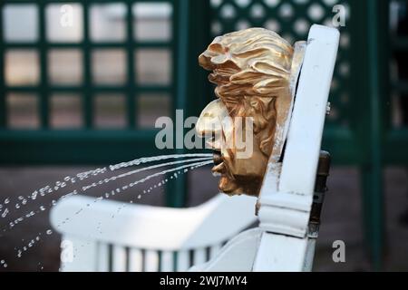 Fontana con faccia dorata montata su panchina bianca a Peterhof, Russia Foto Stock