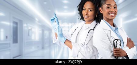 Due donne sicure di sé in camici da laboratorio bianchi sono pronte Foto Stock