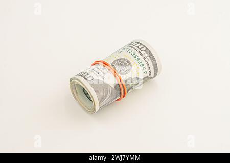 banconote da 100 dollari su un rotolo isolato su sfondo bianco. Ha arrotolato i soldi isolati su sfondo bianco. Dollari isolati su sfondo bianco. Dollaro ro Foto Stock