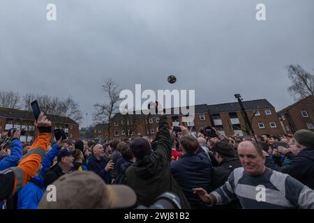 Ashbourne, Regno Unito. 13 febbraio 2024. Primo giorno della partita annuale di calcio Shrovetide nel villaggio di Ashbourne nel Derbyshire. Il gioco è giocato da due sezioni della città, gli Up'ards e i Down'ards. Le squadre dipendono da quale lato del brook Henmore è nato un giocatore. La partita si gioca in due giorni, martedì grasso e mercoledì delle ceneri, con due periodi di otto ore con i gol a tre miglia di distanza. Non c'è limite al numero di giocatori e si applicano pochissime regole. Penelope Barritt/Alamy Live News Foto Stock