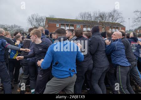 Ashbourne, Regno Unito. 13 febbraio 2024. Primo giorno della partita annuale di calcio Shrovetide nel villaggio di Ashbourne nel Derbyshire. Il gioco è giocato da due sezioni della città, gli Up'ards e i Down'ards. Le squadre dipendono da quale lato del brook Henmore è nato un giocatore. La partita si gioca in due giorni, martedì grasso e mercoledì delle ceneri, con due periodi di otto ore con i gol a tre miglia di distanza. Non c'è limite al numero di giocatori e si applicano pochissime regole. Penelope Barritt/Alamy Live News Foto Stock