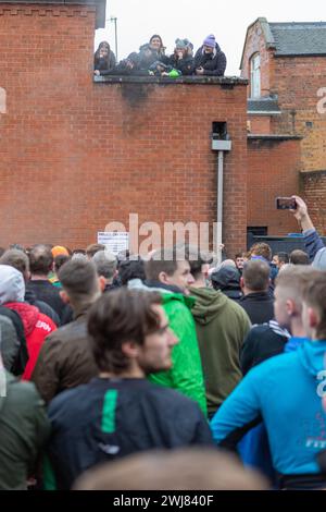 Ashbourne, Regno Unito. 13 febbraio 2024. Primo giorno della partita annuale di calcio Shrovetide nel villaggio di Ashbourne nel Derbyshire. Il gioco è giocato da due sezioni della città, gli Up'ards e i Down'ards. Le squadre dipendono da quale lato del brook Henmore è nato un giocatore. La partita si gioca in due giorni, martedì grasso e mercoledì delle ceneri, con due periodi di otto ore con i gol a tre miglia di distanza. Non c'è limite al numero di giocatori e si applicano pochissime regole. Penelope Barritt/Alamy Live News Foto Stock